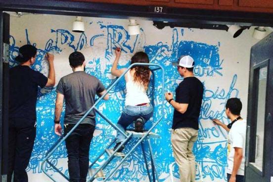 Students putting up artwork in the rage gallery